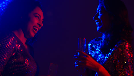 Nahaufnahme-Von-Zwei-Frauen-In-Einer-Nachtclubbar-Oder-Disco,-Die-Sich-Unterhalten-Und-Alkohol-Trinken